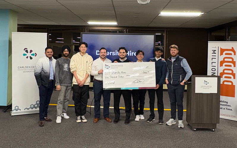 Team Diversity Hires holding the overall winner check