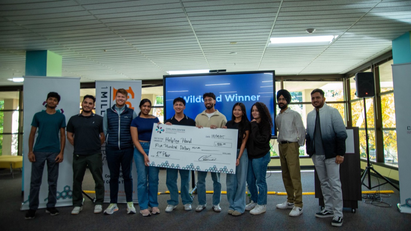 Team Helping Hand holding the first-place check